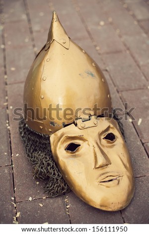 Golden medieval slavic helmet with a face mask, vertical shot