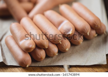 Close-up of raw mini sausages on a packaging paper, horizontal shot