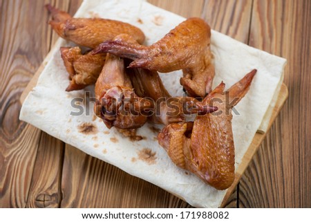 Above view of smoked chicken wings on pita bread