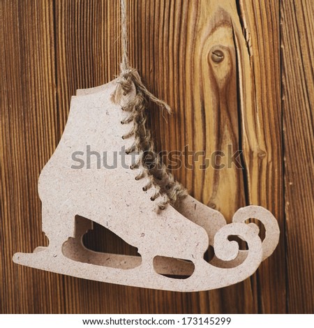 Decorative figure skates made of carton over wooden background