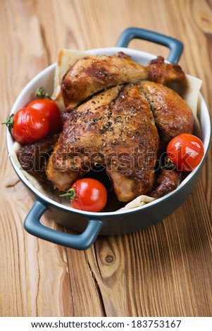 Whole baked chicken with tomatoes, vertical shot
