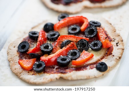 Close-up of mini pizza with olives, bell pepper and cheese