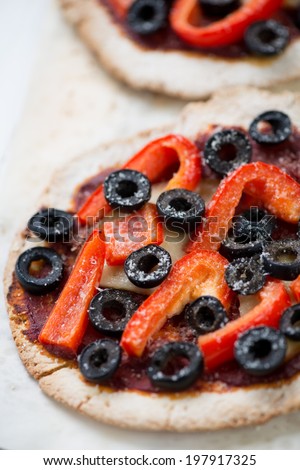 Mini pizza with olives, bell pepper and cheese, close-up