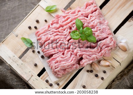 Raw turkey minced meat with basil, pepper and garlic, above view