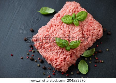 Minced turkey meat with pepper and green basil, view from above