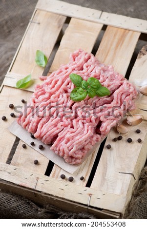 Raw ground meat with basil, pepper and garlic, vertical shot