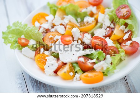 Salad with sliced tomatoes, feta cheese and salad leaves
