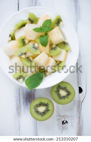 Fruit salad with melon and kiwi slices, view from above