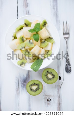Above view of melon and kiwi salad in a glass plate, studio shot