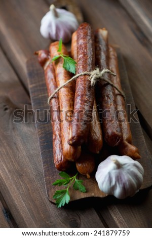 Smoked sausages with fresh parsley and garlic, studio shot