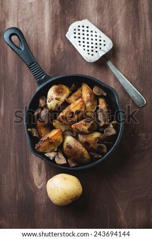 Roasted potatoes with peel in a cast-iron frying pan, above view