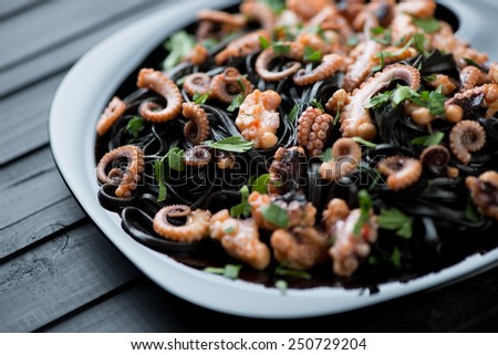 Squid ink tagliatelle with sliced octopuses and parsley