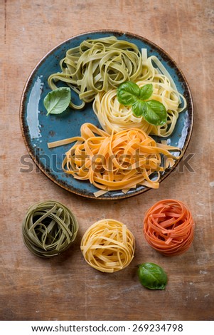 Tagliatelle of italian flag colors with green basil, above view