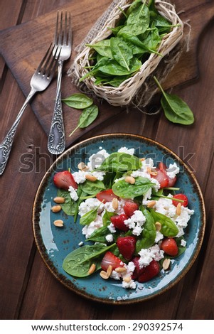 Salad with spinach, strawberry, cheese and peanuts, top view