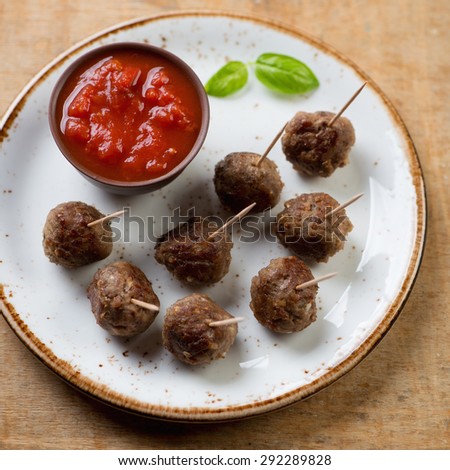 Close-up of skewers with meatballs and a dipping sauce