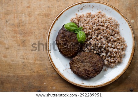 Above view of grilled meat cutlets and buckwheat, studio shot