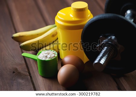 Shaker with a dumbbell, protein and protein food, close-up