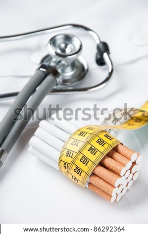 Cigarettes with tape-line and stethoscope on doctor’s smock