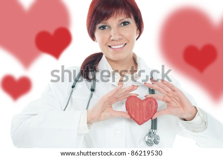 Studio portrait of successful cute young female cardiologist holding a wooden heart