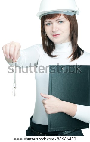 Friendly female caucasian architect in hard-hat holding writing pad and demonstrating the keys from a residential house
