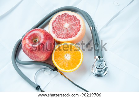 Healthy life-style concept with fresh fruits and stethoscope on doctor's smock