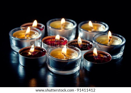 Close-up of tea light candles burning in the darkness