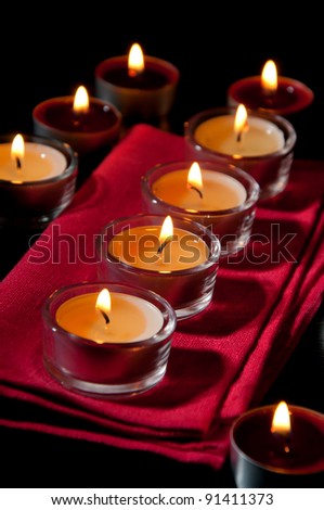Row of burning tea light candles