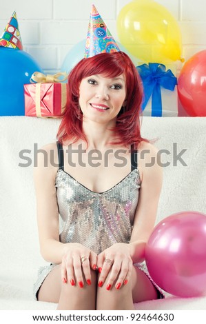 Positive red-haired party woman smiling and looking at camera