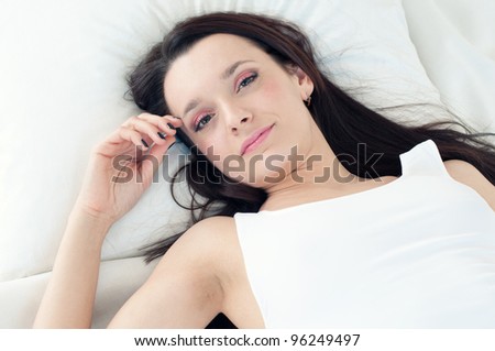 Sweet dreams: young dark-haired woman lying in bed