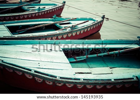 Old boats on brown waters of Ganges river, Varanasi, India