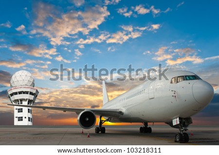 Commercial airplane at the airport with control tower
