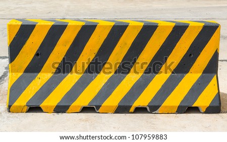 yellow and black concrete barriers blocking the road