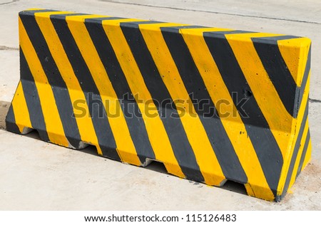 Yellow and black concrete barriers blocking on the road