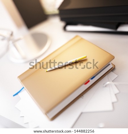 Beige personal organizer and pen on office desk