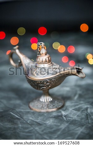 Aladdin Lamp on grey textile in front of bokeh lights