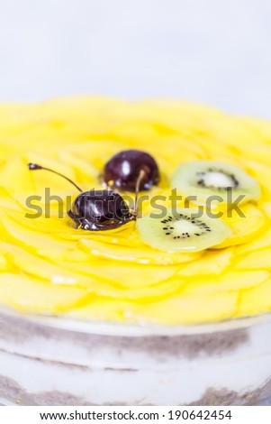 Mango cake decorated with cherry and kiwi