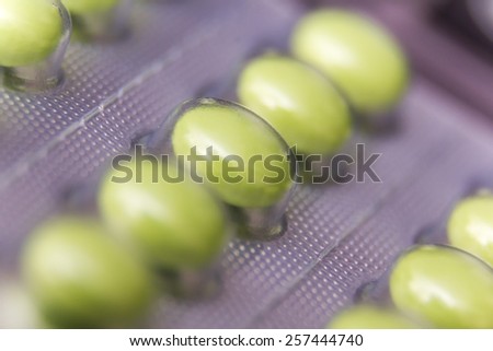 Closeup on green tablets in plastic cover
