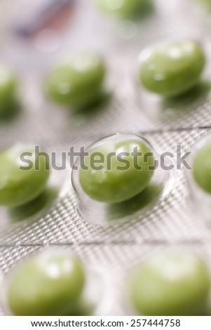 Closeup on green tablets in plastic cover