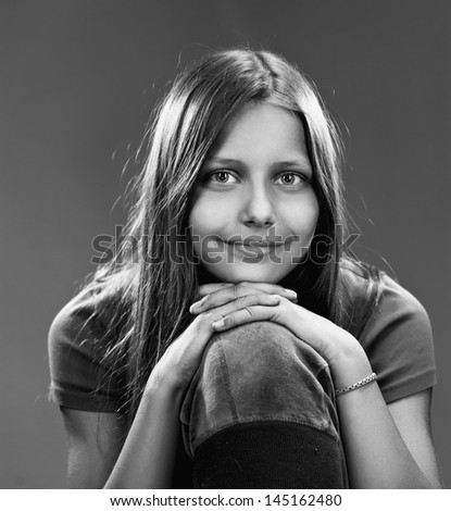 Portrait of a smiling teen girl, black and white, closeup, studio shot