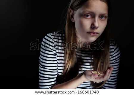 Dark portrait of a drug addicted teenager girl with pills