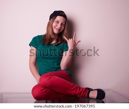 Portrait of a teen girl sitting on table, studio shot