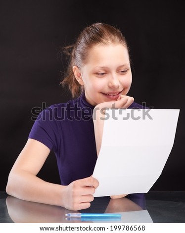 Happy teen girl reading letter and smiling