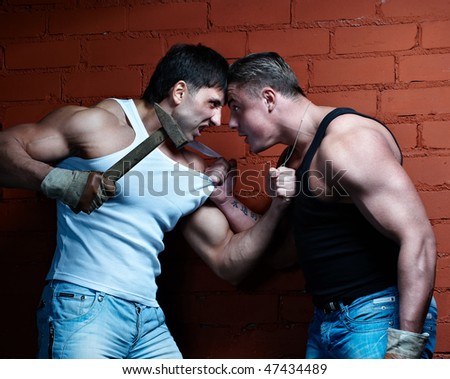 Two muscular angry guys threaten each other