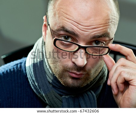 Portrait of a bald serious man in glasses