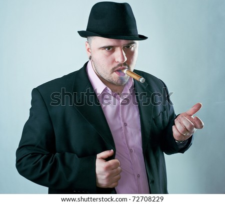 Macho man with cigar in black hat