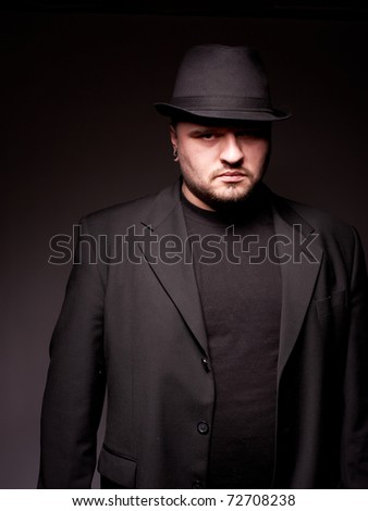 Handsome man in black suite with hat