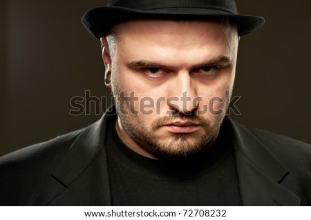 Handsome man in black suite with hat