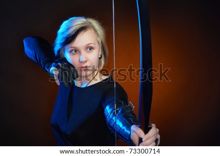 Young woman with bow and arrows, studio shot