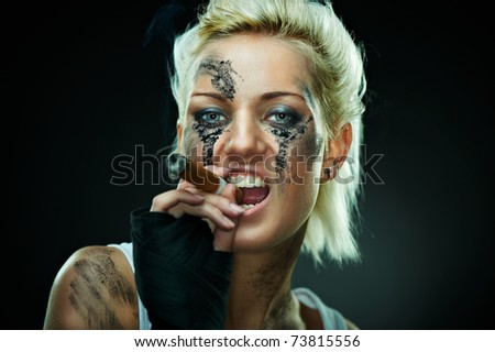 Closeup portrait of a beautiful young caucasian punk woman with dirty face and cigar in her mouth