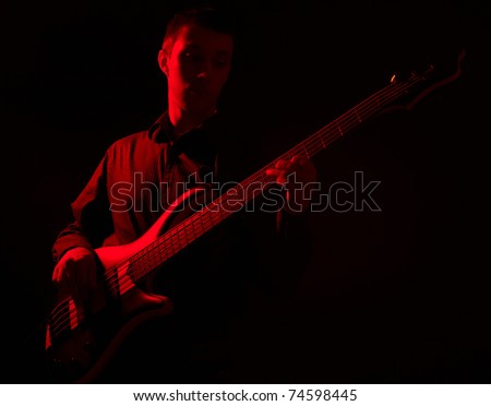 Dark portrait of musician with bass guitar